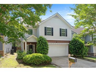 Charming two-story home features a well-manicured lawn, attached garage, and classic architectural details at 5712 Grande River Rd, Atlanta, GA 30349