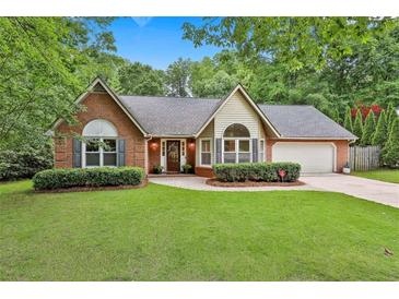Charming single-story home with a brick facade, well-manicured lawn, and mature trees at 108 Shawville Ln, Peachtree City, GA 30269