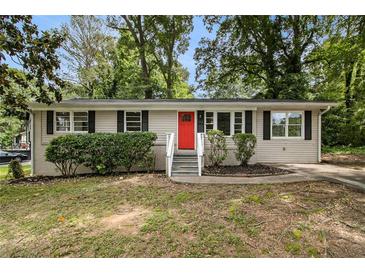 Charming single-story home with red front door and well-maintained landscaping at 3294 Renault Se Rd, Atlanta, GA 30354