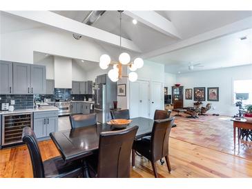 Open concept dining room featuring modern light fixture, adjacent to kitchen with stainless steel appliances at 1143 Church Nw St, Atlanta, GA 30318