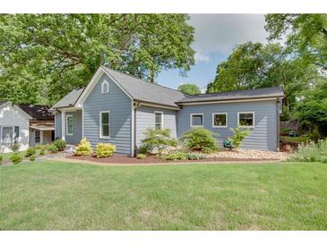 Charming home with mature trees, landscaping, and gray siding at 1143 Church Nw St, Atlanta, GA 30318