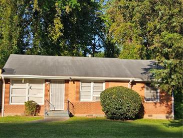 Charming single-story brick home featuring a well-maintained lawn and mature trees at 1990 Shamrock Dr, Decatur, GA 30032