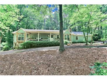 Charming home with stone accents, covered porch, and lush landscaping in a wooded setting at 3320 Bryant Ln, Marietta, GA 30066