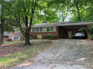 Charming single-story brick home featuring a covered carport and mature trees in a quiet neighborhood at 185 W Lake Nw Dr, Atlanta, GA 30314