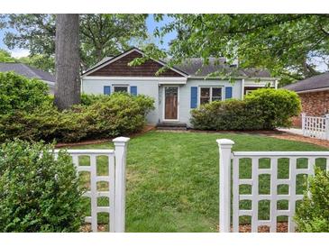 Charming home featuring a well-manicured lawn and a classic white picket fence at 220 Sisson Ne Ave, Atlanta, GA 30317