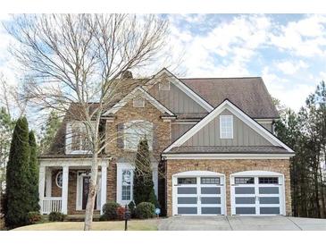 Stunning two-story home featuring a stone and siding facade and a two-car garage with modern doors at 149 Stargrass Way, Grayson, GA 30017