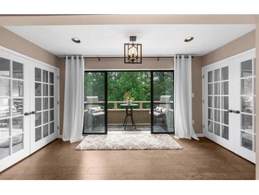 Bright sunroom featuring hardwood floors, neutral paint, and a cozy balcony area with nature views at 25305 Plantation Ne Dr, Atlanta, GA 30324