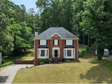 Charming two-story brick home with manicured lawn and mature trees in a peaceful, wooded setting at 3075 Milford Sw, Marietta, GA 30008
