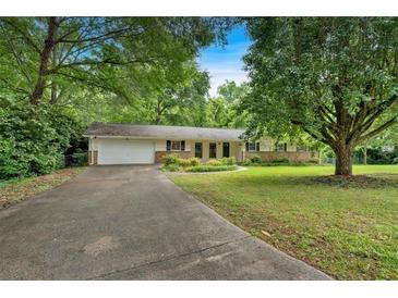 Charming ranch-style home featuring a well-manicured lawn and an attached two-car garage at 450 S Susan Creek Dr, Stone Mountain, GA 30083