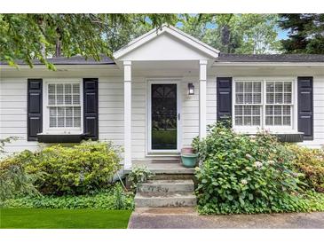 Charming front door with white trim and black shutters surrounded by lush landscaping at 1091 Napier Se St, Atlanta, GA 30316