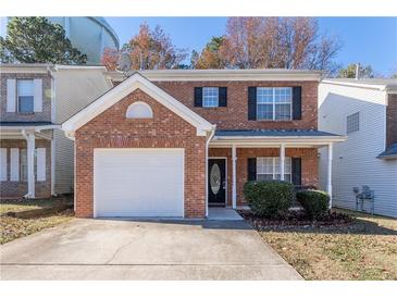 Charming red brick two-story home with a well-manicured front yard and a one car garage at 538 Shadowmoore Dr, Riverdale, GA 30274