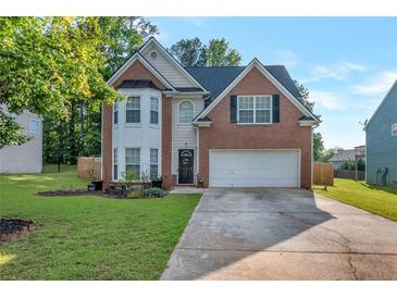 Charming two-story brick home features an attached two-car garage and a well-manicured front lawn at 575 Chapel Walk Ln, Lawrenceville, GA 30045