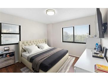 Comfortable bedroom featuring a tufted headboard, windows, and a mounted television at 795 Hammond Dr # 505, Atlanta, GA 30328