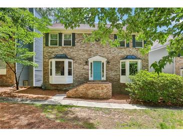 Charming brick two-story home with a bright blue front door and manicured landscaping at 2356 Defoors Ferry Nw Rd, Atlanta, GA 30318