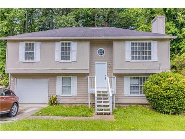 Charming home featuring a neutral exterior with a well-maintained front yard and bright white trim at 5339 Biffle Downs Rd, Stone Mountain, GA 30088