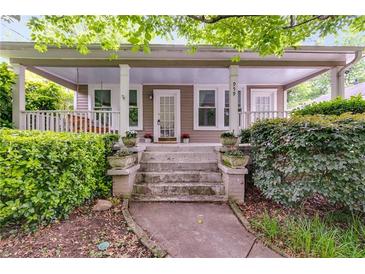 Charming front porch with swing, potted plants, and inviting curb appeal at 959 Hall Nw Pl, Atlanta, GA 30318