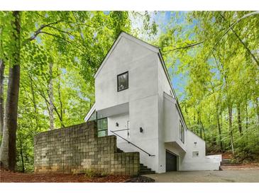 Striking modern exterior featuring a crisp white facade and lush green surroundings at 165 River North Walk, Atlanta, GA 30328
