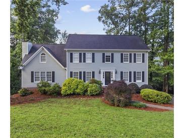 Charming two-story home with a well-manicured lawn and mature landscaping at 4468 Windsor Oaks Dr, Marietta, GA 30066