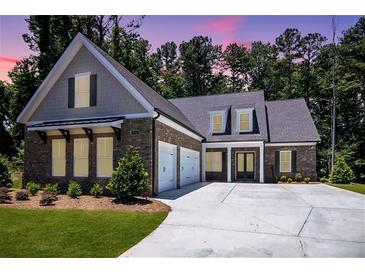 Beautifully landscaped single-Gathering home with a brick facade, two-car garage, and inviting double door entry at 1150 Sweet Mia Ln, Powder Springs, GA 30127