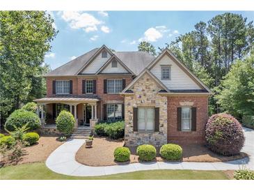 Charming two-story brick home with manicured landscaping and a welcoming front porch at 5925 Water Mark Dr, Cumming, GA 30040