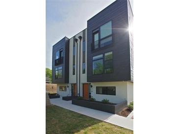 Modern townhome featuring a dark gray and cream color scheme with a small decorative balcony and manicured landscaping at 1153 Reynolds Square Ln # 16, Atlanta, GA 30307