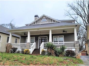 Charming home with a large covered front porch, white railings and stone pillar bases at 2132 Memorial Se Dr, Atlanta, GA 30317