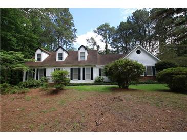 Charming traditional home featuring black shutters, dormer windows, and mature landscaping at , Loganville, GA 30052