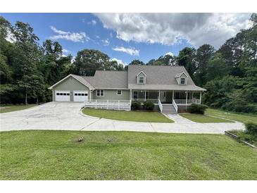Charming home featuring a spacious front yard, two-car garage, and welcoming front porch at 3133 Callie Still Rd, Lawrenceville, GA 30045