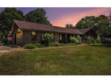 Charming one-story brick home featuring lush landscaping, an attached garage, and a well-manicured front lawn at 2452 Camp Mitchell Rd, Grayson, GA 30017