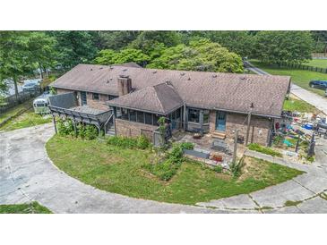 Backyard of brick home with a rustic deck, screened porch, patio, and a circular drive at 2452 Camp Mitchell Rd, Grayson, GA 30017