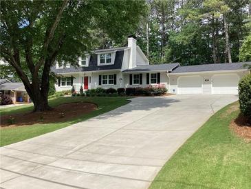 Charming home features a bright red door, a two-car garage, and mature trees at 2917 Townley Cir, Atlanta, GA 30340