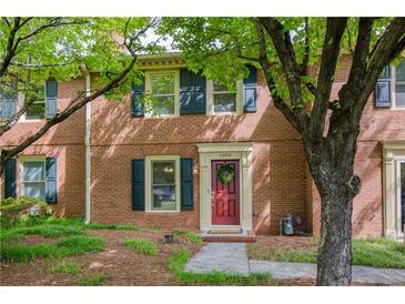 Charming brick home featuring a red front door and a well-manicured lawn at 1092 Old Roswell Rd, Roswell, GA 30076