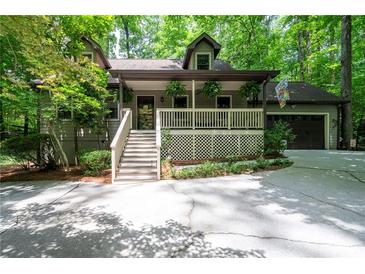 Charming home featuring a covered porch, attached garage, and inviting curb appeal with mature trees at 1560 Bubbling Creek Ne Rd, Atlanta, GA 30319