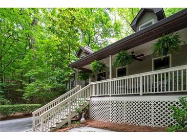 Inviting covered front porch with white railings, steps and lush greenery, creating a welcoming entrance at 1560 Bubbling Creek Ne Rd, Atlanta, GA 30319