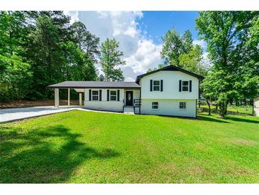 Charming two-story home with a well-maintained lawn, carport, and classic curb appeal at 550 Oglesby Bridge Se Rd, Conyers, GA 30094