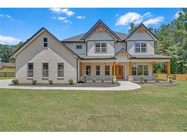 Inviting two-story home with brick and siding, featuring a covered porch and manicured front yard at 1461 Leach Dr, Lawrenceville, GA 30045