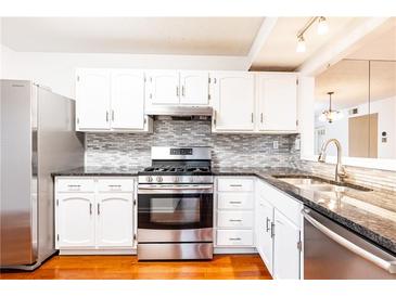 Bright kitchen with stainless steel appliances, white cabinets, and tile backsplash at 2901 Lenox Ne Way # 902, Atlanta, GA 30324