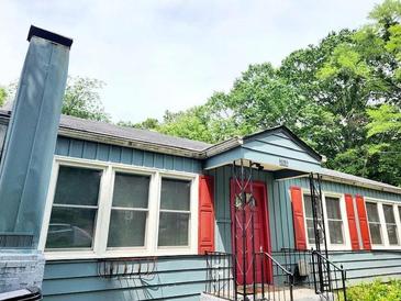 Charming home featuring blue siding, red shutters, a striking red front door, and a classic chimney design at 2404 Shallowford Ter, Atlanta, GA 30341