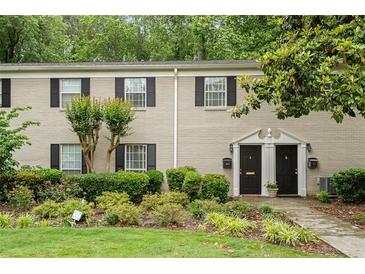 Charming two-story townhome featuring black shutters, well maintained lawn, and a landscaped front yard at 3663 Essex Ave # 29, Atlanta, GA 30339