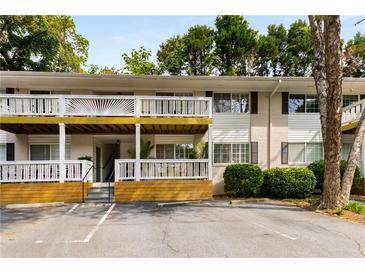 Multi-Gathering home with white siding, a covered balcony, designated parking, and mature trees at 1990 Wellbourne Dr # 5, Atlanta, GA 30324