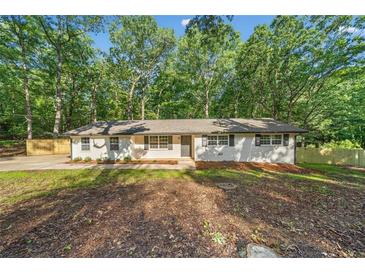 Charming ranch-style home with freshly painted exterior and well-maintained front yard landscaping at 5155 Oakdale Ct, Douglasville, GA 30135