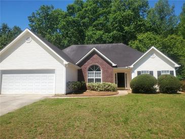 Charming one-story home with manicured lawn, brick accents, and an attached two-car garage at 155 Overlook Dr, Covington, GA 30016