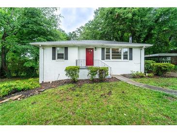 Charming single-story home with a red front door, white brick, and lush landscaping at 218 Woodview Se Ln, Smyrna, GA 30082