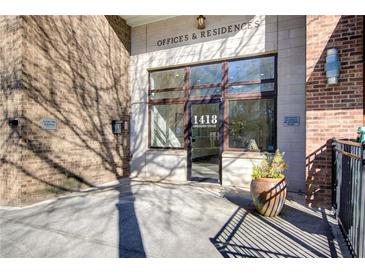 Building entrance with brick and stone exterior, featuring large windows and signage for offices and residences at 1418 Dresden Ne Dr # 385, Brookhaven, GA 30319