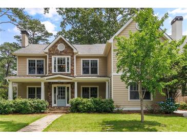 Charming two-story home featuring stone accents, a covered porch, lush landscaping, and a well-manicured lawn at 2217 Virginia Ne Pl, Atlanta, GA 30305