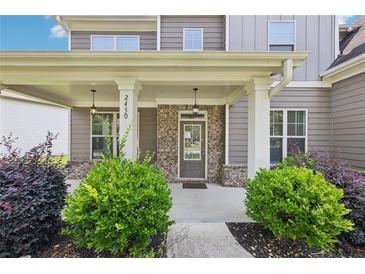 Charming covered front porch with brick accents and manicured landscaping, offering a welcoming entrance to the home at 2450 Overlook Ave, Lithonia, GA 30058