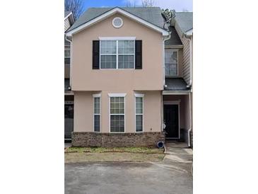 Charming townhome featuring a neutral facade, black shutters, a gray roof, and an inviting front entrance at 7314 Bridlewood Ct, Jonesboro, GA 30236