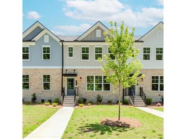Charming townhome exterior with a well-manicured lawn and inviting entrances at 1240 Ainsworth Aly # 39, Sugar Hill, GA 30518