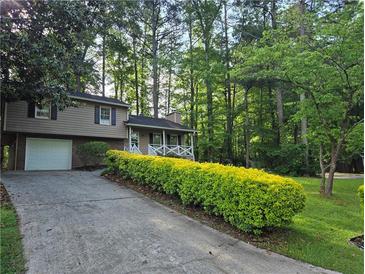 Charming two-story home with a welcoming front porch and well-maintained landscaping at 4015 Woodland Nw Dr, Kennesaw, GA 30152