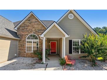 Charming home featuring a stone facade and a welcoming red front door at 1625 Alcovy River Dr, Dacula, GA 30019